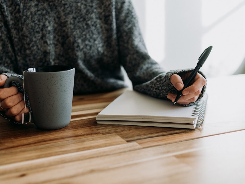 Person som skriver anteckningar vid ett skrivbord